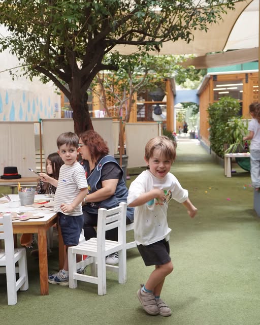Maestras y niños en el jardín de OMBU