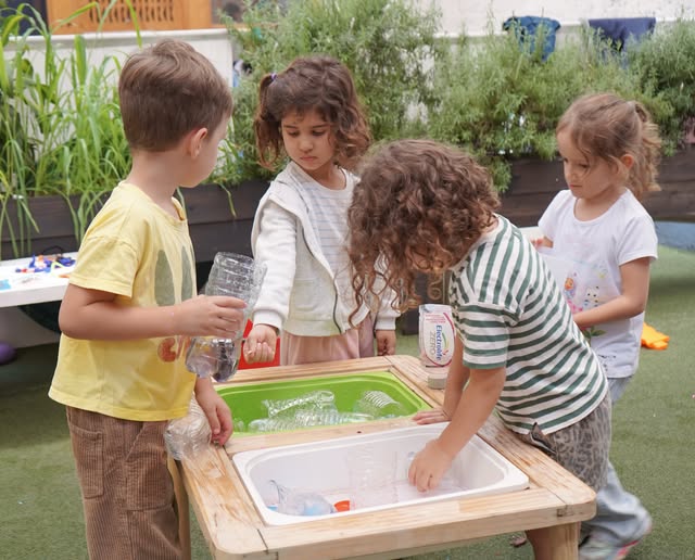 Niños investigando en la mesa de agua