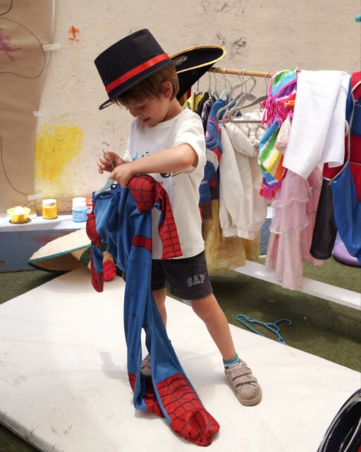 Un niño eligiendo su disfraz en el área de juego simbólico